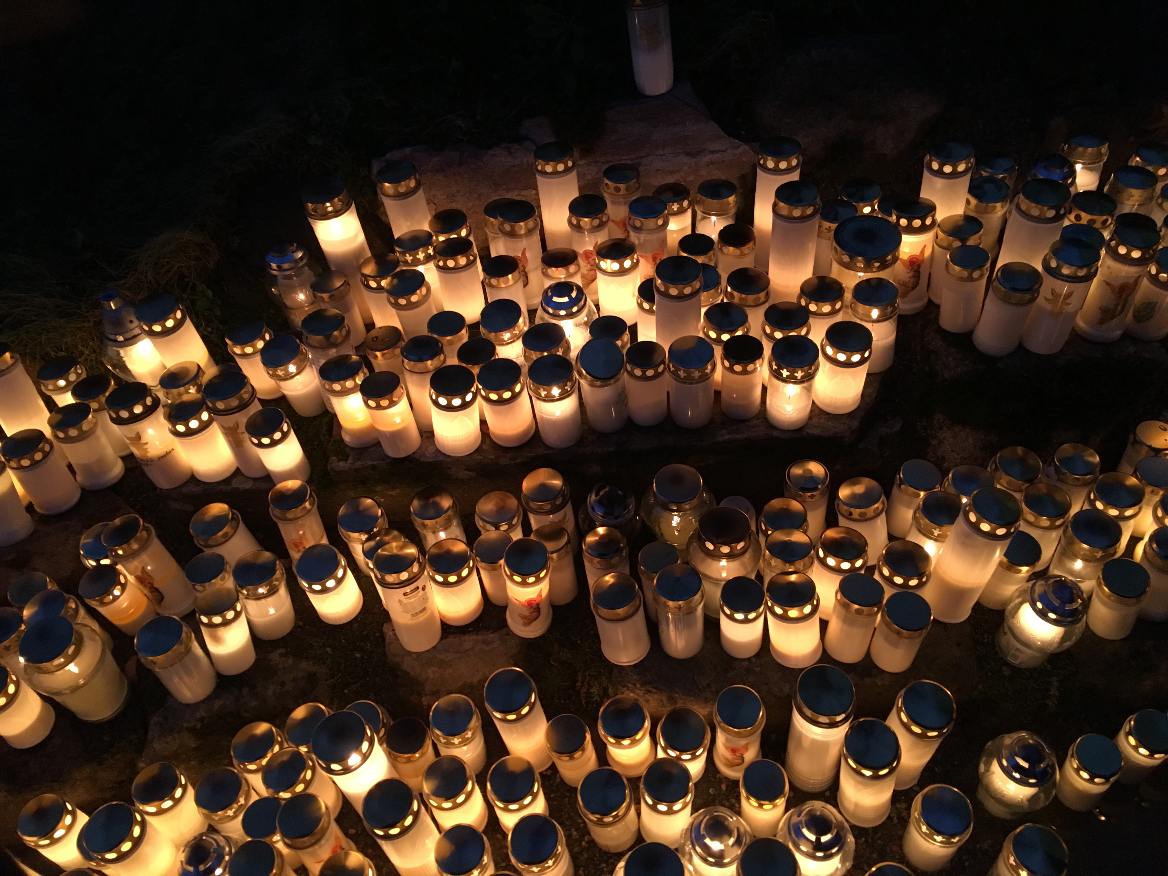 Kynttilät palavat pimeällä hautausmaalla