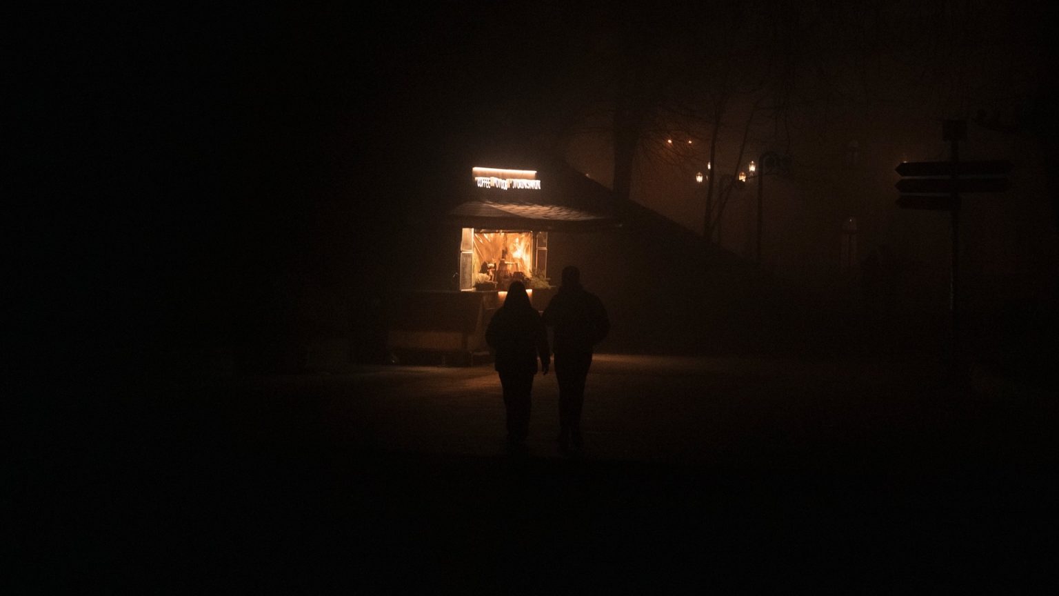 Kaksi ihmistä pimeässä kaupungissa