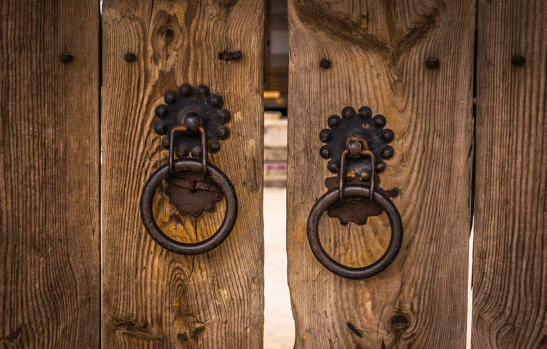 vanhanaikaiset puu-ovet, joissa rautaiset ovenkahvat